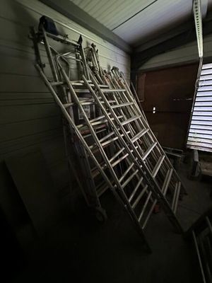 une pile d'échelles appuyées contre un mur dans une pièce