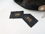 a black hat and a pair of tags on a white table