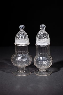 two clear glass salt and pepper shakers on a black surface