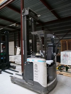 un chariot élévateur dans un entrepôt rempli de palettes et de cartons