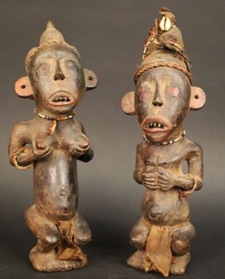 deux statues en bois représentant deux hommes coiffés d'un chapeau