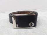 black leather belt with a silver buckle on a white surface