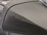 a close up of a car ' s side mirror with a car in the background