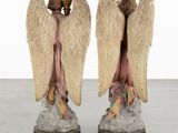 two statues of angels sitting on top of each other