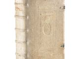 an old book sitting on top of a white table next to a white wall