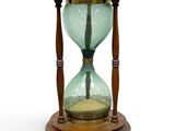 an hourglass with a tree in it on a wooden stand