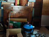a messy room with a bed, dresser, and other items on the floor