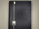 a black binder with a white logo on it sitting on top of a table
