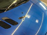 a close up of a blue sports car parked in a garage