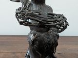 a statue of a man sitting on a horse with a basket on his back