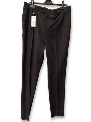 the black pants are hanging on a hanger on a white wall