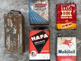 four old oil cans and a canister on the floor