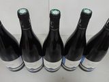 six bottles of wine are lined up in a row on a table