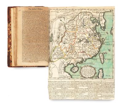 un livre ouvert, sur lequel figure une carte, posé sur une table