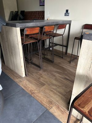 tables and chairs in a room with a bar and a refrigerator