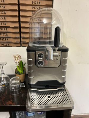 une machine à café posée sur une table devant une boîte à pizza