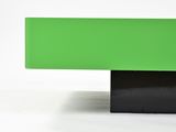 a green table with a black base on a white background