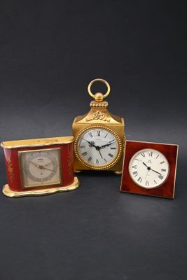 deux horloges et un cadre photo posés sur une table, sur fond noir
