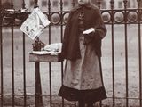 woman standing in front of a fence holding a plate of food
