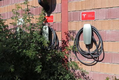 un mur de briques rouges auquel sont fixés plusieurs câbles électriques