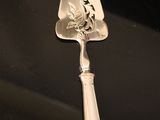 a silver spoon with a bird on it sitting on a table