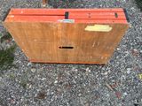 a wooden box sitting on the ground with a sticker on it