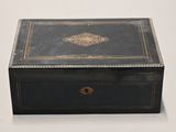 an old black box with a gold decoration on the lid