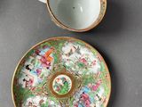 a cup and saucer sitting on a table next to a plate