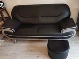 a black and white leather couch and ottoman in a living room