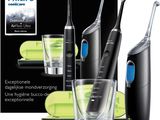 trois brosses à dents électriques et un verre posés devant une boîte