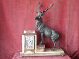 a statue of a stag on top of a clock on a table