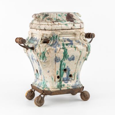 un vase blanc et bleu monté sur roulettes, posé sur une surface blanche