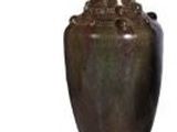 un vase brun posé sur une surface blanche