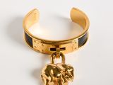 bracelet manchette plaqué or avec pendentif en forme d'éléphant sur fond blanc