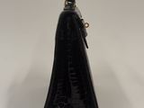 the black purse is sitting on a white surface