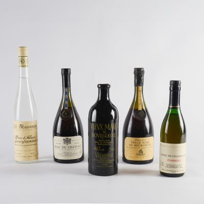 six bouteilles de vin sont alignées sur une surface blanche