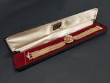 an image of a gold watch in a case on a table