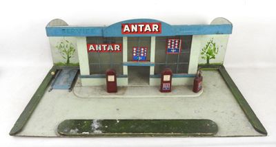une petite maquette de station-service posée sur une surface blanche