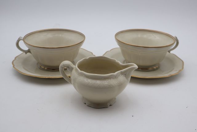 Deux déjeuners et un crémier en porcelaine ivoire avec filet or