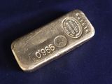 an old silver bar on a blue cloth with a black background