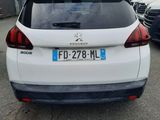 the rear end of a white car parked in a parking lot