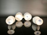 three white cups sitting on a black table