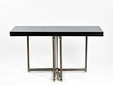 une table noire avec deux pieds en laiton et un plateau noir