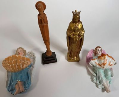 three figurines of angels and a statue of an angel on a pedestal