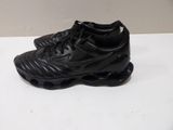 a pair of black soccer shoes on a white table