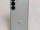 the back of a white phone with four black buttons on it