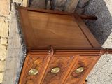 a wooden cabinet with brass knobs on top of it