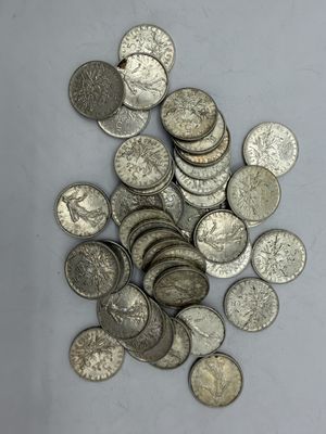 une pile de pièces d'argent posée sur une surface blanche