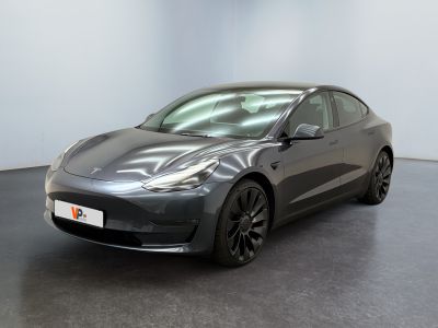 une Tesla Model 3 grise garée dans un showroom