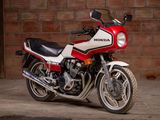 a red and white motorcycle parked in front of a brick wall